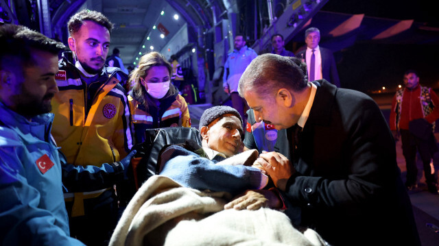 La ministre turque de la Santé, Fahrettin Koca, s'entretenant avec un patient palestinien atteint d'un cancer, qui est passé de Gaza à l'Égypte, après son arrivée à l'aéroport Esenboga d'Ankara, le 16 novembre 2023. 