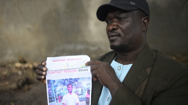 Jacob Inje tient une photo de son neveu alors qu'il attend de donner des échantillons d'ADN pour les victimes du massacre de Shakahola à la morgue du district de Malindi, dans le comté de Kilifi, au Kenya, le 1er mai 2023, suite à la disparition de son neveu en décembre.