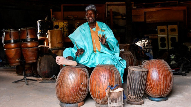 Oumarou Adamou, alias "Maïdouma", joueur et fabricant d'instruments à membrane, fait de la musique dans son atelier situé au sein du Centre de Formation Professionnelle en Musique (CFPM) à Niamey, le 25 octobre 2023. 