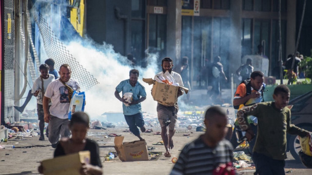 Les foules quittent les magasins avec des marchandises au milieu d'un état de troubles à Port Moresby,  la capitale de la Papouasie-Nouvelle-Guinée, le 10 janvier 2024.