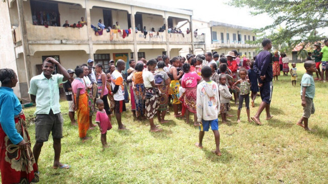 Les habitants se rassemblent devant la salle communautaire à la suite d'un puissant cyclone se dirigeait vers le Mozambique après avoir frappé Madagascar.