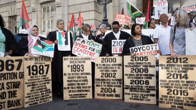 Un groupe d'avocats et de défenseurs brandissant des pancartes lors d'une manifestation interreligieuse en solidarité avec le peuple palestinien devant la Haute Cour du Cap, le 11 janvier 2024. 