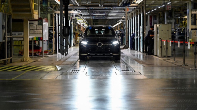 Les employés travaillant sur une ligne de production dans une usine automobile Mercedes Benz lors d'une tournée médiatique à Pékin.