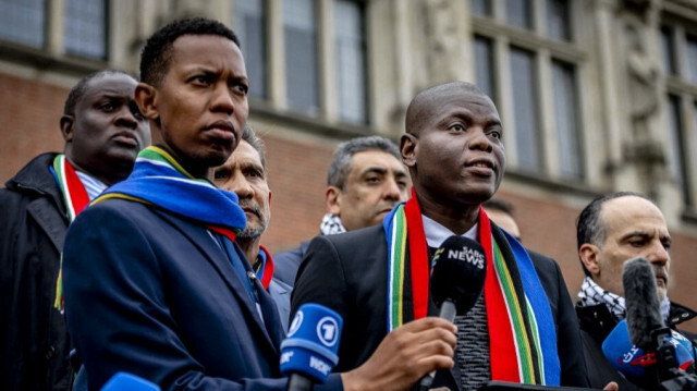 Le ministre sud-africain de la Justice, Ronald Lamola (à droite), fait des déclarations aux journalistes à l'extérieur de la Cour internationale de justice (CIJ) après le premier jour d'audience sur le cas de génocide intenté par l'Afrique du Sud contre Israël, à La Haye le 11 janvier 2024. 