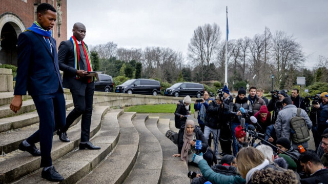 Le Ministre de la Justice d'Afrique du Sud, Ronald Lamola (à droite), sort du bâtiment pour adresser des remarques aux journalistes à l'extérieur de la Cour internationale de Justice (CIJ) après le premier jour d'audiences sur le cas de génocide contre Israël porté par l'Afrique du Sud, à La Haye,  le 11 janvier 2024. 