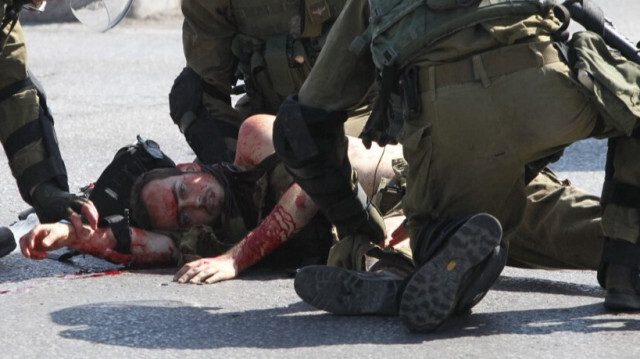 Les forces de sécurité israéliennes s'occupent d'un soldat blessé à Hébron en Cisjordanie occupée, le 16 octobre 2015.