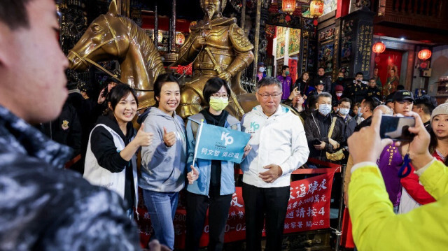 Ko Wen-je, candidat à la présidence de Taïwan du Parti populaire de Taïwan (TPP) d'opposition et sa compagne de course Cynthia Wu ainsi que des partisans posent pour des photos au marché nocturne de Miaokou à Keelung le 10 janvier 2024.