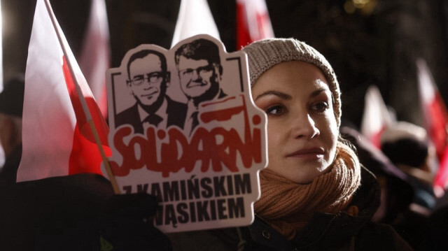 Une femme brandit une pancarte portant l'inscription "Solidarité avec Kaminski et Wasik" lors d'une manifestation de soutien à l'ancien ministre de l'intérieur Mariusz Kaminski et à son adjoint Maciej Wasik après leur arrestation, devant le Parlement polonais, à Varsovie, le 11 janvier 2024.