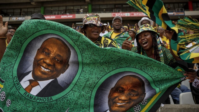 Des partisans du Congrès national africain (ANC) tiennent une photo du président sud-africain et président de l'ANC Cyril Ramaphosa lors du 112e rassemblement anniversaire du Congrès national africain (ANC) à Mbombela, le 13 janvier 2024.