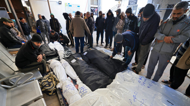 Des personnes pleurant les corps enveloppés de leurs proches tués lors d'un bombardement israélien le 13 janvier 2024, dans la cour de l'hôpital Al-Najjar à Rafah, dans le sud de la bande de Gaza.