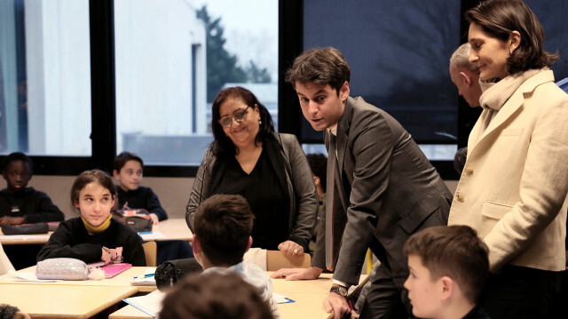 Le Premier ministre français Gabriel Attal s'adressant aux élèves à côté de la ministre française de l'Éducation, des Sports et des Jeux olympiques Amélie Oudea-Castera lors d'une visite au collège Saint-Exupery, à Andrésy, au nord-ouest de Paris, le 12 janvier 2024.