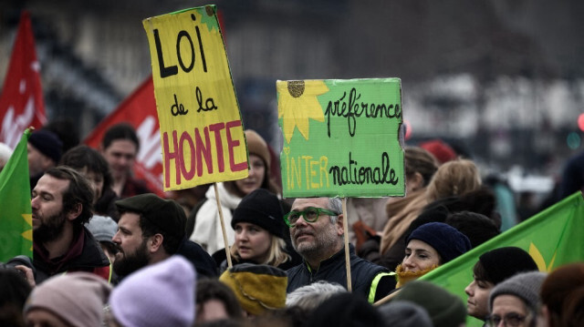 Des manifestants brandissent une pancarte portant l'inscription "loi de la honte" lors d'un rassemblement contre la nouvelle loi française sur l'immigration, à Bordeaux, en France, le 14 janvier 2024.