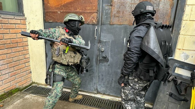 Des soldats et des policiers reprenant le contrôle de la prison de Turi à Cuenca, en Équateur, le 14 janvier 2024.