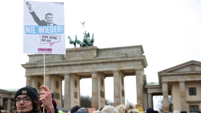 Un manifestant brandit une pancarte représentant le leader de l'AfD de Thuringe, Bjoern Hoecke, faisant le salut nazi accompagné de la mention "Plus jamais ça", lors d'une manifestation de militants de différents groupes contre l'extrémisme de droite et la politique du parti d'extrême droite allemand Alternative pour l'Allemagne (AfD) devant la porte de Brandebourg à Berlin, en Allemagne, le 14 janvier 2024. 