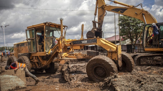 Des ouvriers enlèvent la boue d'une rue à l'aide d'excavateurs suite à des glissements de terrain et des inondations provoqués par de fortes pluies à Katesh, en Tanzanie, le 5 décembre 2023. 