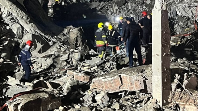 Des pompiers et du personnel de sécurité inspectant les décombres d'un bâtiment sur un site touché par une attaque de missiles lancée par le Corps des gardiens de la révolution islamique de l'Iran, à Erbil au nord de l'Irak, le 16 janvier 2024.