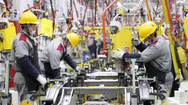 Des employés travaillant sur une chaîne de montage de voitures dans une usine automobile de Pékin à Qingdao, dans la province du Shandong, dans l'est de la Chine.