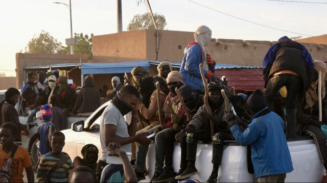 Des migrants sont assis à l'arrière d'un pick-up quelques minutes avant de se rendre à la frontière libyenne à Agadez, le 2 janvier 2024. 