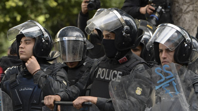 La police tunisienne monte la garde à un poste de contrôle devant le ministère de l'Intérieur lors d'une manifestation contre le président à Tunis le 14 janvier 2023.