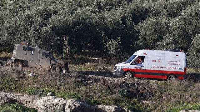 Un véhicule des forces israéliennes bloque la route alors qu'une ambulance du Croissant-Rouge palestinien essaie de rentrer en Palestine occupée, le 13 janvier 2024.