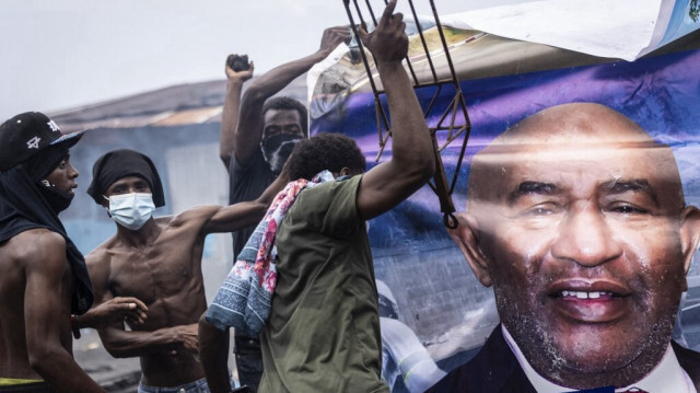 Des partisans de l'opposition manifestent devant un panneau d'affichage représentant le président sortant des Comores, Azali Assoumani, à Moroni le 17 janvier 2024, en réaction à l'annonce des résultats de l'élection présidentielle.