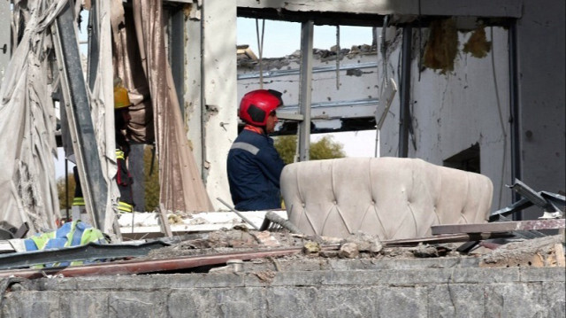 Une équipe de défense civile mène des opérations de recherche et de sauvetage dans un bâtiment endommagé à la suite d'un tir de missile lancé par l'Iran.