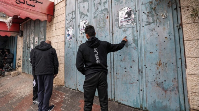 Les impacts de balles qui criblent les volets métalliques d'un magasin fermé où des Palestiniens ont été abattus, au cours d'une opération militaire israélienne, à l'est de Qalqilya en Palestine occupée, le 2 janvier 2024.