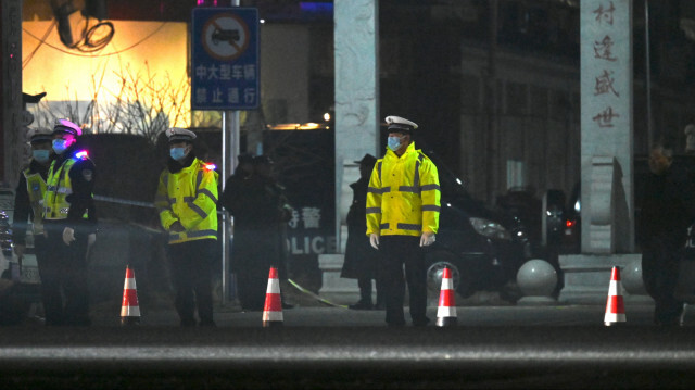 La police se tenant devant une école où 13 personnes ont péri dans un incendie à Yanshanpu, dans la province centrale du Henan, en Chine, le 20 janvier 2024. 