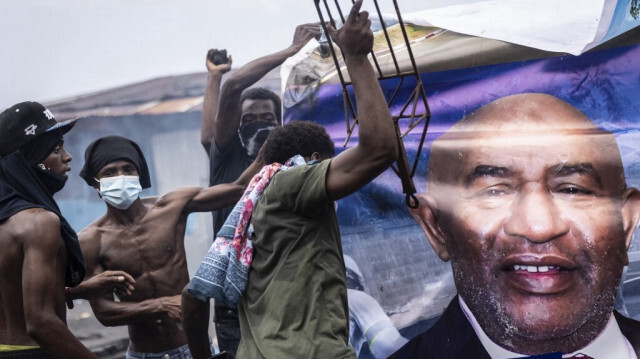 Des partisans de l'opposition détruisent un panneau d'affichage représentant le président sortant des Comores et président de la Convention pour le renouveau des Comores (CRC), Azali Assoumani, lors d'une manifestation à Moroni, le 17 janvier 2024.