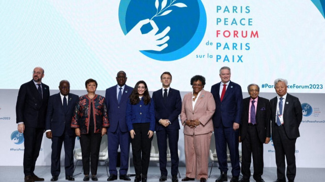 (De gauche à droite) Charles Michel, président du Conseil européen, Nana Akufo-Addo, président du Ghana, Kristalina Georgieva, directrice générale du Fonds monétaire international (FMI), Macky Sall, président du Sénégal, Emmanuel Macron, président français, Mia Amor Mottley, Première ministre de la Barbade, Mathias Cormann, secrétaire général de l'Organisation de coopération et de développement économiques (OCDE), N. K. Singh, président de l'Institut de la croissance économique, et Jin Liqun, président de la Banque asiatique d'investissement dans les infrastructures (AIIB), posent pour une photo de famille lors de la cérémonie d'ouverture du Forum de Paris sur la paix au Palais Brongniart à Paris, le 10 novembre 2023. 