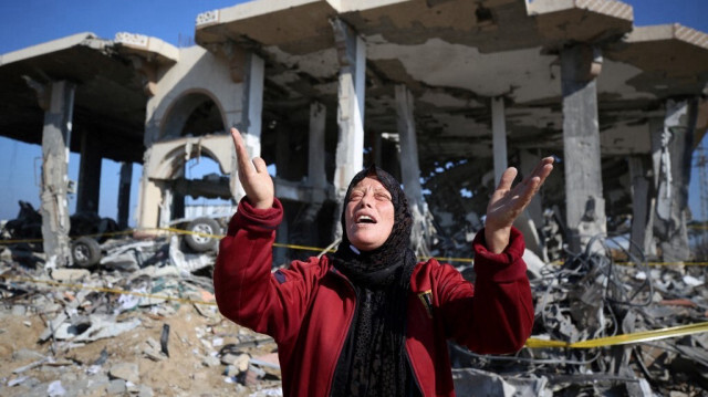 Une femme palestinienne réagit devant un bâtiment détruit dans le camp de réfugiés d'Al-Maghazi, dans le centre de la bande de Gaza, le 16 janvier 2024.