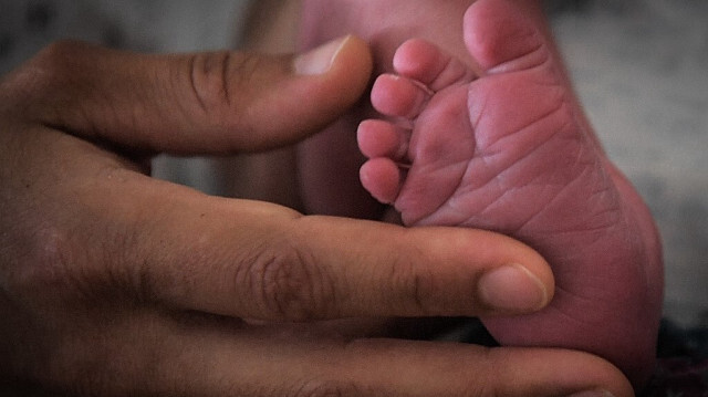 Une mère tient les pieds de son nouveau-né à l'hôpital de Nantes, dans l'ouest de la France, le 7 juillet 2018. 