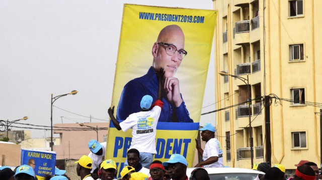 Des manifestants de l'opposition sénégalaise brandissant des photos de l'ancien ministre Karim Wade lors d'une marche à Dakar.