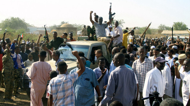 Des partisans et des membres de la résistance populaire armée soudanaise, qui soutient l'armée, brandissent leurs armes sur une camionnette lors d'une réunion avec le gouverneur de la ville à Gedaref, au Soudan, le 16 janvier 2024, dans le cadre du conflit actuel au Soudan entre l'armée et les paramilitaires.