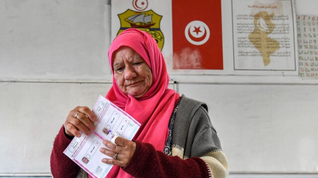 Une femme tenant son bulletin s'apprête à voter lors des élections locales de 2023 dans la localité de Mnihla, dans la province d'Ariana, en périphérie de Tunis, le 24 décembre 2023.