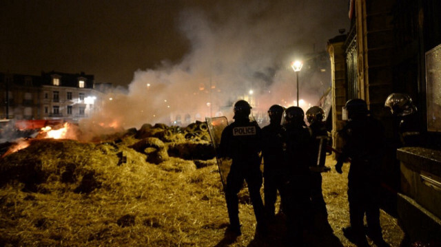 La police française est prête à éteindre les déchets agricoles brûlants déversés devant les portes de la préfecture de Sarthe, lors d'une manifestation convoquée par les syndicats d'agriculteurs au Mans, dans l'ouest de la France, le 15 février 2022.
