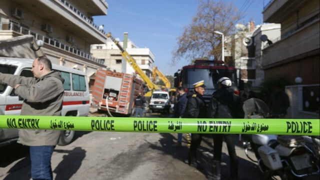 Le personnel de sécurité et d'urgence boucle la zone entourant un bâtiment détruit lors d'une attaque israélienne à Damas, le 20 janvier 2024.