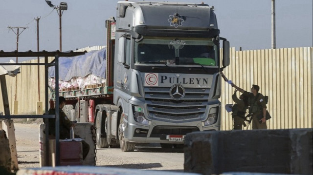 Des soldats israéliens contrôlent un camion égyptien transportant de l'aide humanitaire du côté israélien du poste frontière de Kerem Shalom avec le sud de la bande de Gaza, le 22 janvier 2024.