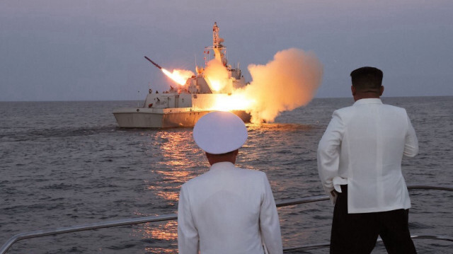 Le dirigeant nord-coréen Kim Jong Un (à droite) regardant un missile de croisière stratégique lancé à partir d'un navire de garde marin du 2e Escadron de navires de surface de la flotte de la mer de l'Est, également connu sous le nom de mer du Japon, le 21 août 2023.