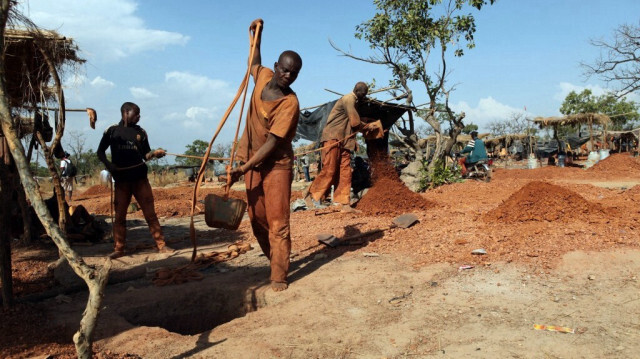 Les mineurs d'or vident des seaux de terre extraite des tunnels souterrains à Koflatie, au Mali, le 28 octobre 2014, une mine située à quelques kilomètres de la frontière avec son voisin du sud-ouest, la Guinée. 