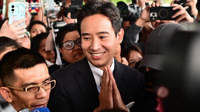 L'ancien candidat thaïlandais au Premier ministre et ancien chef du parti Move Forward, Pita Limjaroenrat (C), fait des gestes alors qu'il est entouré de médias devant la Cour constitutionnelle à Bangkok le 24 janvier 2024.