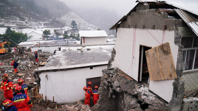 Les sauveteurs recherchent des victimes disparues dans une maison endommagée à la suite d'un glissement de terrain dans le village de Liangshui à Zhaotong, dans la province du Yunnan, dans le sud-ouest de la Chine, le 23 janvier 2024.