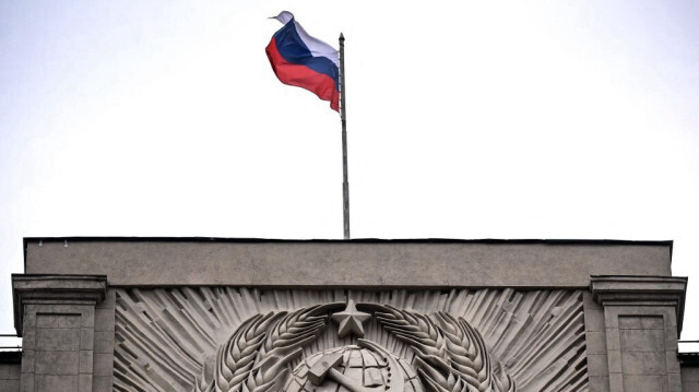 Le drapeau national russe hissé au sommet de la Douma d'État, chambre basse du Parlement russe, avec l'emblème de l'Union soviétique sur la façade du bâtiment datant de l'ère soviétique, dans le centre de Moscou, le 14 juillet 2023.