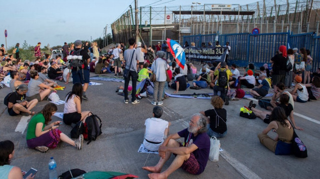 Des manifestants près de la clôture de Melilla, l'enclave espagnole au Maroc, lors d'une manifestation organisée le 24 juin 2022, un an après qu'une tentative massive des migrants de prendre d'assaut la clôture de plusieurs mètres de haut a fait au moins 23 morts.