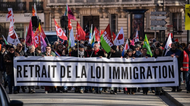 Des manifestants brandissent une banderole pour revendiquer le retrait de la loi sur l'immigration lors d'un rassemblement contre cette loi controversée, à Toulouse, dans le sud de la France, le 20 janvier 2024.