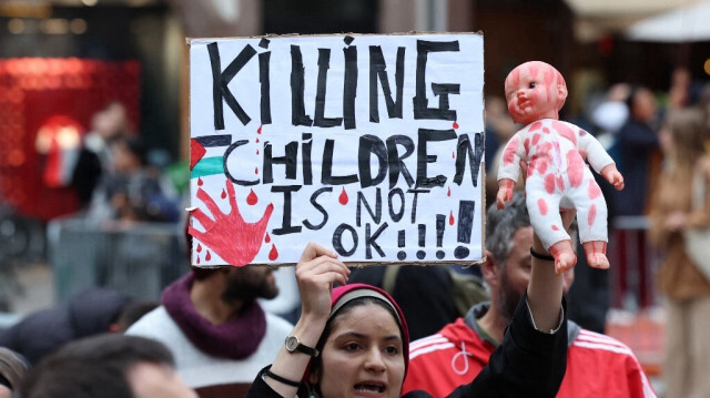 Un manifestant brandit une pancarte et une poupée représentant les bébés tués par l'armée d'occupation israélienne, lors d'un rassemblement de solidarité avec les Palestiniens de la bande de Gaza, à Strasbourg, le 28 octobre 2023.