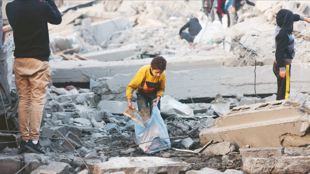 Mısır sınırındaki Refah kentinde atık merkezlerini dolaşan çoğu çocuk Filistinliler, yemek pişirmek için ateş yakmak üzere atık karton, poşet ve plastik topluyor.