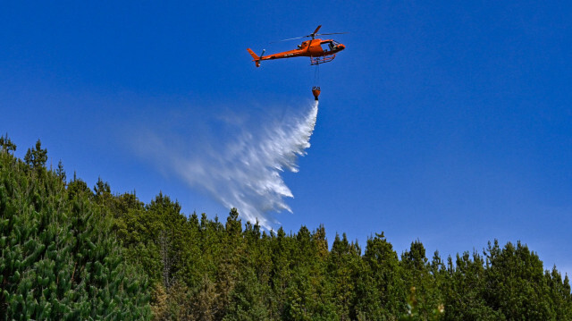 Un hélicoptère larguant de l'eau pour éteindre un feu de forêt à Nemocon, en Colombie, le 26 janvier 2024. La Colombie a demandé hier l'aide des pays membres des Nations unies pour éteindre une trentaine d'incendies de forêt qui ravagent plusieurs régions et noient la capitale, Bogota, dans la fumée.