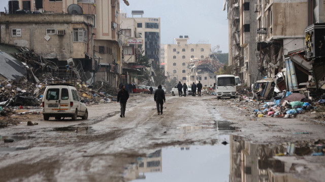 Les gens essaient de marcher sur des routes endommagées remplies d'eau de pluie pendant les précipitations à Gaza, le 27 janvier 2024.