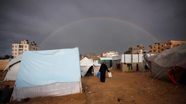 Un arc-en-ciel apparaît dans le ciel à la suite de pluies, alors que des familles palestiniennes, s'abritent dans le village de tentes dans des conditions difficiles pour se protéger des attaques israéliennes à Deir Al Balah, à Gaza, le 27 janvier 2024.